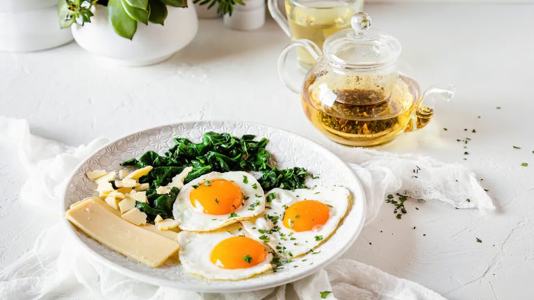 Desayuno vegetariano rico en proteínas con queso huevos y espinacas