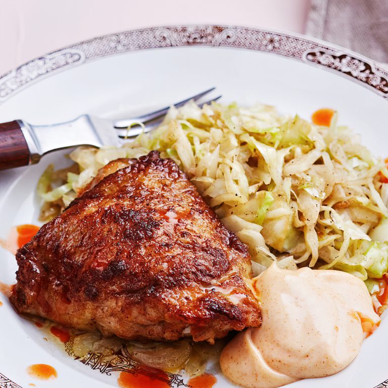 Estas jugosas presas de pollo tienen justo la cantidad perfecta de picante y se sirven con una suave pero sabrosa mayonesa de paprika y con repollo frito en mantequilla. Es una comida cetogénica que querrás preparar una y otra vez.